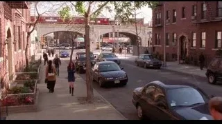 busy city street with train on bridge — Spider Man