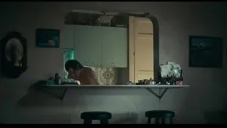 shirtless man eating in dimly lit room — Joker