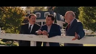 man speaking into microphone in room — The Wolf Of Wall Street