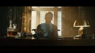 man reading paper at desk by window — Deadpool 2