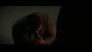 Man in suit kneeling in dark room — Creed 3