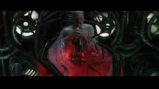 bald man cutting red liquid with scissors — The Matrix