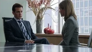 man and woman conversing at office desk — Suits