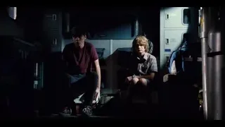 Two young men sitting in dimly lit train car — Jurassic World