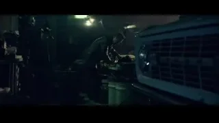 Man working on car in dimly lit garage — John Wick