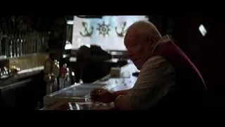 elderly man holding whiskey in dimly lit bar — Batman: The Dark Knight