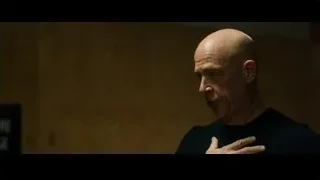 bald man speaking in dimly lit room — Whiplash