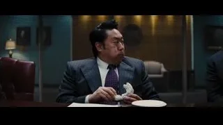 man in suit eating cake at desk — The Wolf Of Wall Street