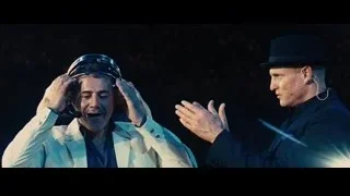 two men on stage with headsets — Now You See Me
