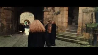 people in black robes walking through stone archway — Harry Potter and the Philosophers Stone