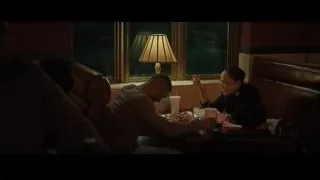 People sitting at table in dimly lit restaurant — Creed 2