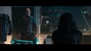man in suit holding gun in kitchen — Deadpool 2