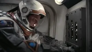 man in space suit operating spaceship control panel — Interstellar