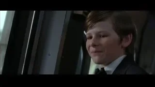 Young boy in tuxedo looking out window — Batman