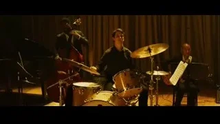 young man at piano with musicians in dimly lit room — Whiplash