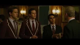 Three young men in suits conversing — The Social Network