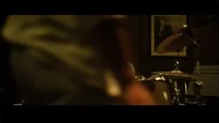 Young man playing drums in dimly lit room — Whiplash