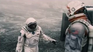 Two astronauts standing on rocky surface — Interstellar