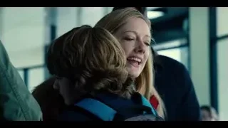 blonde woman in red jacket hugging boy — Jurassic World