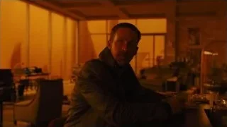 Man deep in thought at table in dimly lit room — Blade Runner 2049