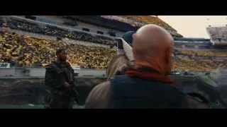 Two men standing in front of stadium — Batman: The Dark Knight Rises