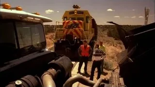 Men inspecting yellow train engine — Breaking Bad