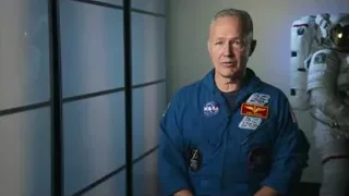 man in blue space suit in front of Earth view — Elon Musk: Return to Space