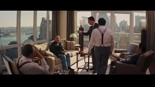 Four men conversing in living room with city view — The Wolf Of Wall Street