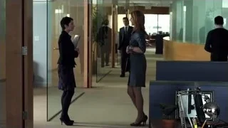 man and woman walking in office lobby — Suits
