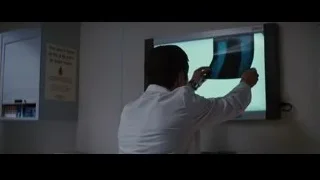 man in lab coat pointing at screen — Batman: The Dark Knight Rises