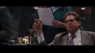 man in suit presenting to group — The Wolf Of Wall Street