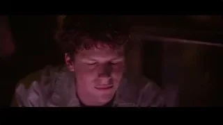 young man with closed eyes in purple light — The Social Network
