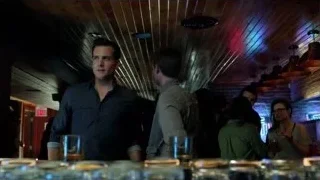 Men conversing at dimly lit bar — Suits