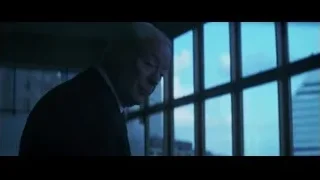 man in suit standing by large window — Batman: The Dark Knight