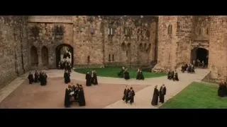 People in black robes in castle courtyard — Harry Potter and the Philosophers Stone