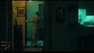 man walking in dimly lit room with open door — Joker