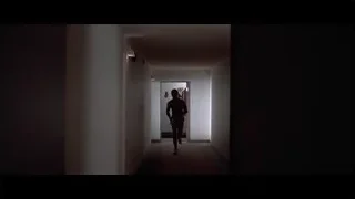 shirtless man in dimly lit hallway — American Psycho