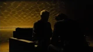 man sitting on couch in dim room — Blade Runner 2049