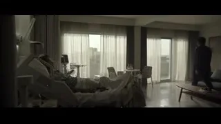 man in suit looking out hospital window — F1
