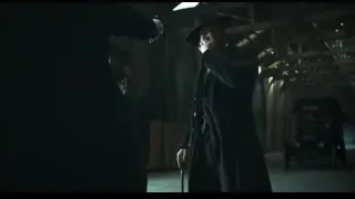 Man in black coat pointing gun at another man — Peaky Blinders