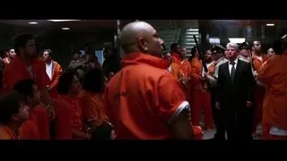 men in prison uniforms with bald man in hallway — Batman: The Dark Knight
