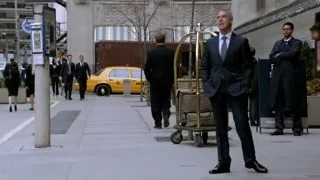 man in suit pushing luggage cart on street — Suits