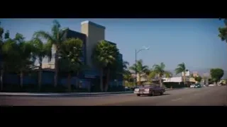 Maroon convertible car driving on street — La La Land