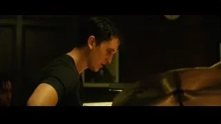 young man playing drums in dimly lit room — Whiplash