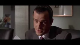 person with mask holding card by monitor — American Psycho