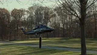 black helicopter flying over field — Succession