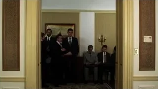 Men in suits in hallway at table — Suits