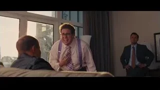 Three men conversing in living room, one surprised — The Wolf Of Wall Street