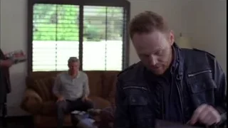 Two men in living room, one holding papers — Breaking Bad