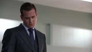 Man in suit standing in a modern office — Suits